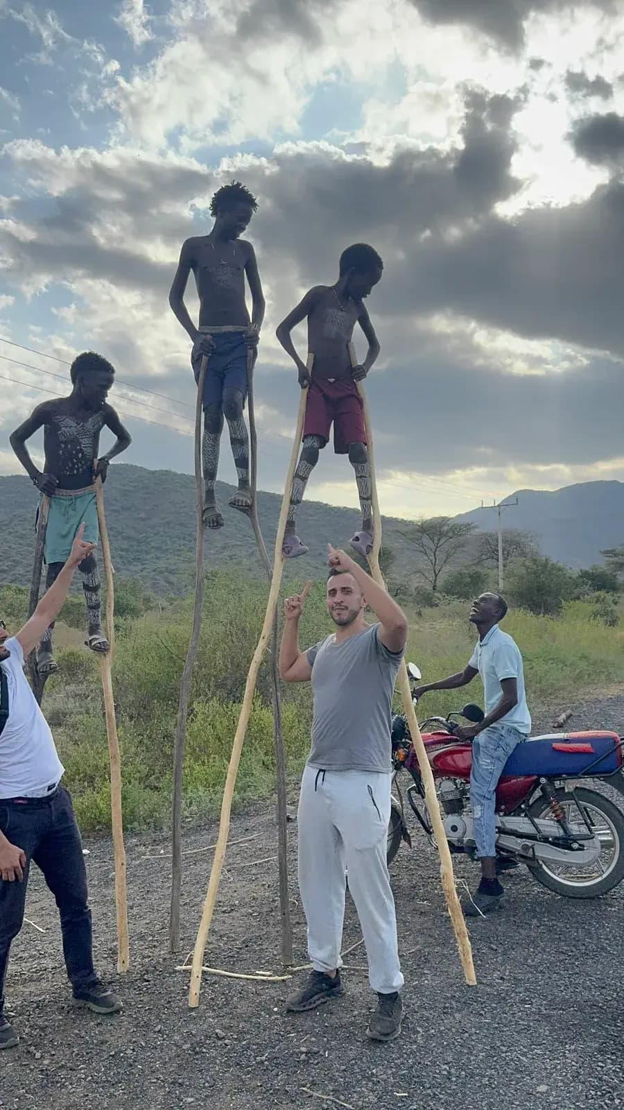 Banna stilt-walkers at sunset with travellers